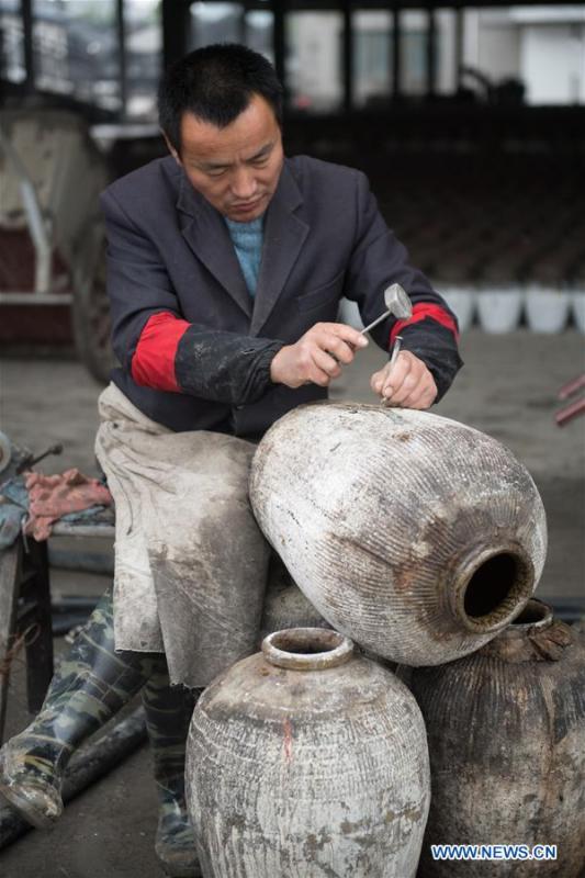 A worker repairs a rice wine jar at Shaoxing Nuerhong Winery Company in Shaoxing, east China\'s Zhejiang Province, Nov. 21, 2018. The company maintains its traditional rice wine brewing method, which is composed of nearly 20 processing steps. (Xinhua/Weng Xinyang)