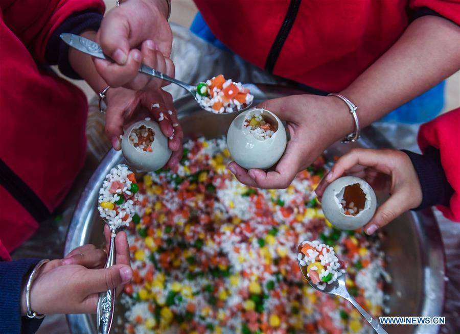 Children use glutinous rice, vegetable and salted duck egg to make a kind of traditional food during an activity at a kindergarten in Lijiaxiang Township of Changxing County, east China\'s Zhejiang Province, Nov. 21, 2018. The activity was held Wednesday to greet the light snow, one of the 24 solar terms of the Chinese lunar calendar. (Xinhua/Xu Yu)