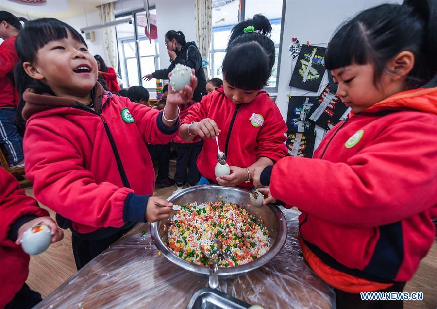 Children use glutinous rice, vegetable and salted duck egg to make a kind of traditional food during an activity at a kindergarten in Lijiaxiang Township of Changxing County, east China\'s Zhejiang Province, Nov. 21, 2018. The activity was held Wednesday to greet the light snow, one of the 24 solar terms of the Chinese lunar calendar. (Xinhua/Xu Yu)