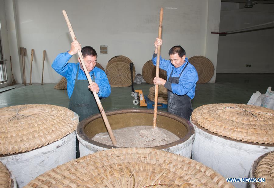 Workers stir the cooked rice to make wine at Shaoxing Nuerhong Winery Company in Shaoxing, east China\'s Zhejiang Province, Nov. 21, 2018. The company maintains its traditional rice wine brewing method, which is composed of nearly 20 processing steps. (Xinhua/Weng Xinyang)