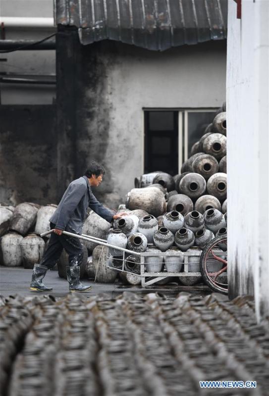 A worker coveys the jars used to contain rice wine at Shaoxing Nuerhong Winery Company in Shaoxing, east China\'s Zhejiang Province, Nov. 21, 2018. The company maintains its traditional rice wine brewing method, which is composed of nearly 20 processing steps. (Xinhua/Weng Xinyang)