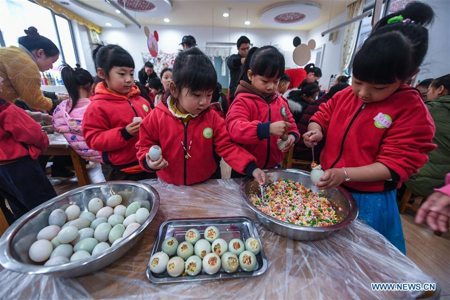 Children use glutinous rice, vegetable and salted duck egg to make a kind of traditional food during an activity at a kindergarten in Lijiaxiang Township of Changxing County, east China\'s Zhejiang Province, Nov. 21, 2018. The activity was held Wednesday to greet the light snow, one of the 24 solar terms of the Chinese lunar calendar. (Xinhua/Xu Yu)