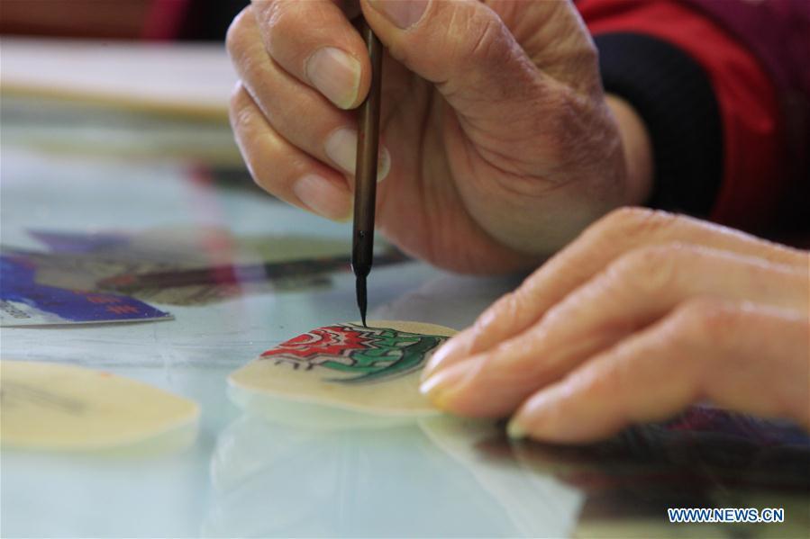 Zhang Kunrong paints on a shadow puppetry piece in Haining City, east China\'s Zhejiang Province, Nov. 20, 2018. Zhang Kunrong, 79, a locally born shadow puppetry player, is an inheritor of the Haining shadow puppetry, a form of traditional theatre acted by colorful silhouette figures made from leather or paper, accompanied by music and singing. A typical variety popular in south China, Haining shadow puppetry, a national intangible cultural heritage, has a history of about 900 years dating back to the Southern Song Dynasty (AD 1127-1279). Obsessed with the shadow play since childhood, Zhang Kunrong was recruited to the provincial shadow puppetry troupe in 1958 and soon became a mainstay after two year\'s practice and in the later years staged performances at home and abroad as Haining shadow puppetry grows popular. Nowadays, Zhang works more on script writing, directing and teaching apprentices. Haining shadow puppetry was listed as one of the state-level intangible cultural heritages in 2006 and was included in the UNESCO Intangible Cultural Heritage of Humanity list in 2011. (Xinhua/Sui Xiankai)