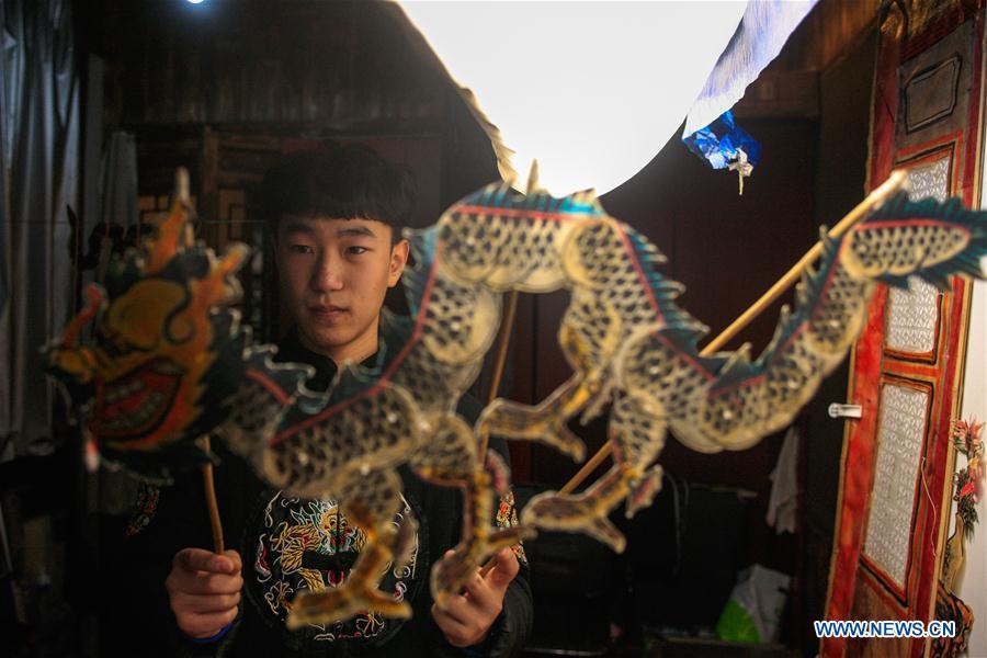 Liu Fan, one of Zhang Kunrong\'s apprentices, prepares before a shadow puppetry show in Haining City, east China\'s Zhejiang Province, Nov. 21, 2018. Zhang Kunrong, 79, a locally born shadow puppetry player, is an inheritor of the Haining shadow puppetry, a form of traditional theatre acted by colorful silhouette figures made from leather or paper, accompanied by music and singing. A typical variety popular in south China, Haining shadow puppetry, a national intangible cultural heritage, has a history of about 900 years dating back to the Southern Song Dynasty (AD 1127-1279). Obsessed with the shadow play since childhood, Zhang Kunrong was recruited to the provincial shadow puppetry troupe in 1958 and soon became a mainstay after two year\'s practice and in the later years staged performances at home and abroad as Haining shadow puppetry grows popular. Nowadays, Zhang works more on script writing, directing and teaching apprentices. Haining shadow puppetry was listed as one of the state-level intangible cultural heritages in 2006 and was included in the UNESCO Intangible Cultural Heritage of Humanity list in 2011. (Xinhua/Zhu Weixi)