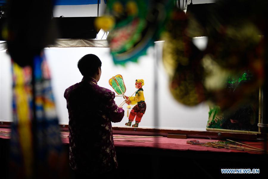 Zhang Kunrong performs in a shadow puppetry show in Haining City, east China\'s Zhejiang Province, Nov. 20, 2018. Zhang Kunrong, 79, a locally born shadow puppetry player, is an inheritor of the Haining shadow puppetry, a form of traditional theatre acted by colorful silhouette figures made from leather or paper, accompanied by music and singing. A typical variety popular in south China, Haining shadow puppetry, a national intangible cultural heritage, has a history of about 900 years dating back to the Southern Song Dynasty (AD 1127-1279). Obsessed with the shadow play since childhood, Zhang Kunrong was recruited to the provincial shadow puppetry troupe in 1958 and soon became a mainstay after two year\'s practice and in the later years staged performances at home and abroad as Haining shadow puppetry grows popular. Nowadays, Zhang works more on script writing, directing and teaching apprentices. Haining shadow puppetry was listed as one of the state-level intangible cultural heritages in 2006 and was included in the UNESCO Intangible Cultural Heritage of Humanity list in 2011. (Xinhua/Huang Zongzhi)