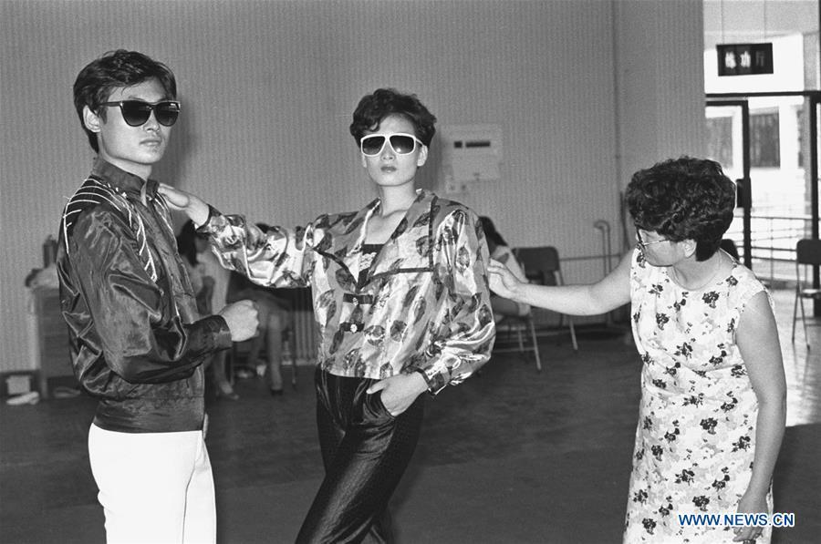 File photo issued on Oct. 9, 1989 shows models of a garment fabric company presenting their creations in Yizheng City, east China\'s Jiangsu Province. From 1978 when China started its reform and opening-up policy, a door to the outside world has been opened. Along with the imported commodities, fashion ideas inevitably slipped into China and since then the country, which was somewhat lack of fashion diversity, started its journey to pursue fashions. Over the past four decades, the thirst for beauty has driven Chinese people to pursue every possible fashionable element. The change first came with dress when colorful and diversified clothing prevailed as against the former dominant blue and grey. For a time, men and women raced to hairdressers\' just for trendy hairdos. Eating McDonald\'s or western cuisine even once was regarded as a fashionable thing. However, the most conspicuous change is that Chinese people have become more inclusive and they tend to accept new fashions, styles and concepts. China nowadays is dazzling the world not only on the fashion stage but in many other fields. Changes in fashions, as a profile of society, has well interpreted the benefits to people brought by China\'s reform and opening-up policy. (Xinhua/Xu Peng)