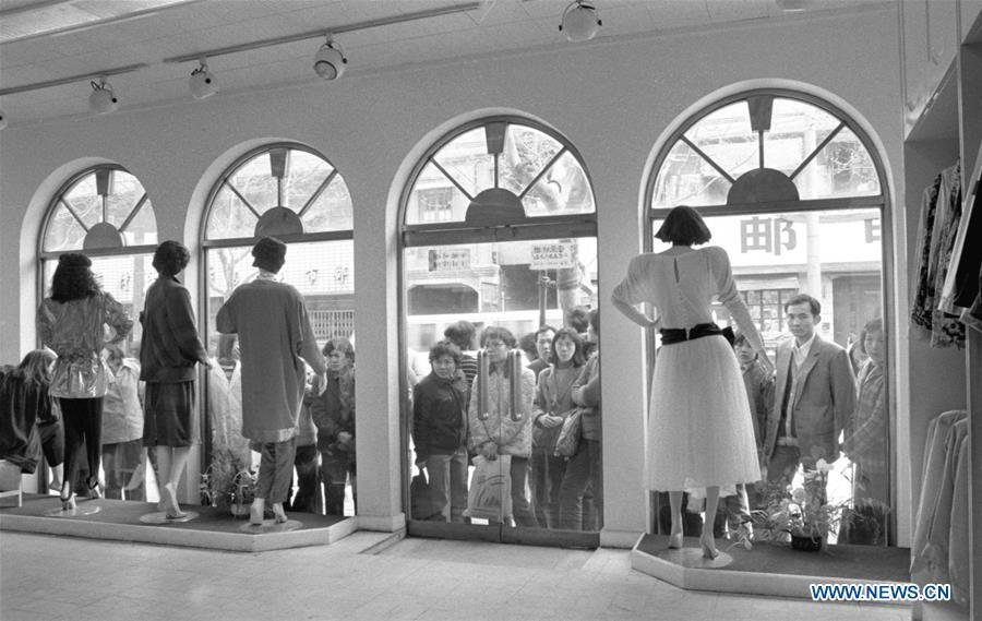 File photo issued on May 15, 1987 shows consumers waiting outside a clothing store of a fashion brand in east China\'s Shanghai. From 1978 when China started its reform and opening-up policy, a door to the outside world has been opened. Along with the imported commodities, fashion ideas inevitably slipped into China and since then the country, which was somewhat lack of fashion diversity, started its journey to pursue fashions. Over the past four decades, the thirst for beauty has driven Chinese people to pursue every possible fashionable element. The change first came with dress when colorful and diversified clothing prevailed as against the former dominant blue and grey. For a time, men and women raced to hairdressers\' just for trendy hairdos. Eating McDonald\'s or western cuisine even once was regarded as a fashionable thing. However, the most conspicuous change is that Chinese people have become more inclusive and they tend to accept new fashions, styles and concepts. China nowadays is dazzling the world not only on the fashion stage but in many other fields. Changes in fashions, as a profile of society, has well interpreted the benefits to people brought by China\'s reform and opening-up policy. (Xinhua/Xu Yigen)