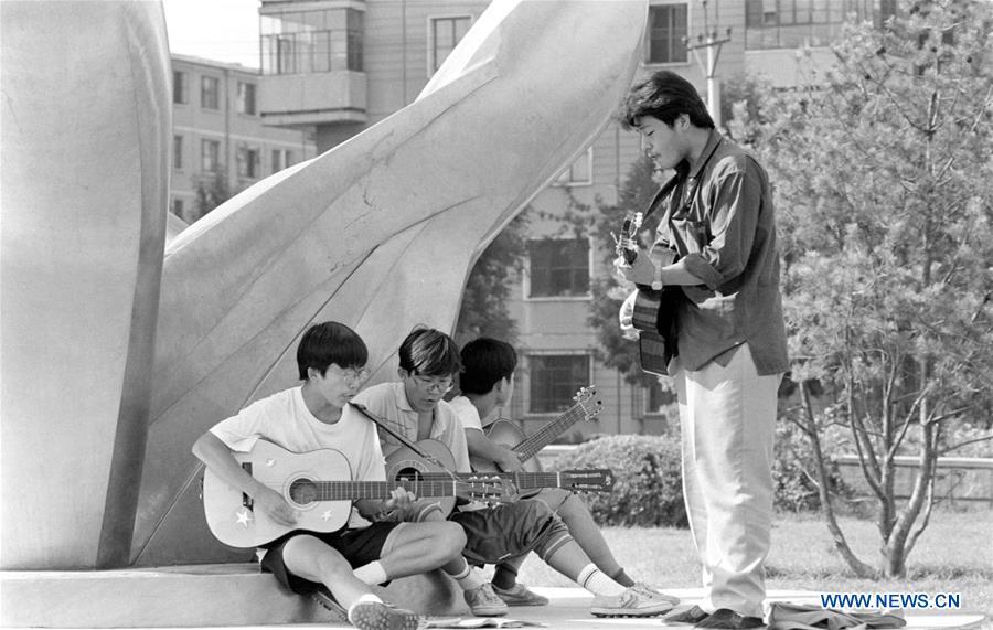 File photo issued on Aug. 24, 1992 shows middle school students singing during a rehearsal at a park in Beijing, capital of China. From 1978 when China started its reform and opening-up policy, a door to the outside world has been opened. Along with the imported commodities, fashion ideas inevitably slipped into China and since then the country, which was somewhat lack of fashion diversity, started its journey to pursue fashions. Over the past four decades, the thirst for beauty has driven Chinese people to pursue every possible fashionable element. The change first came with dress when colorful and diversified clothing prevailed as against the former dominant blue and grey. For a time, men and women raced to hairdressers\' just for trendy hairdos. Eating McDonald\'s or western cuisine even once was regarded as a fashionable thing. However, the most conspicuous change is that Chinese people have become more inclusive and they tend to accept new fashions, styles and concepts. China nowadays is dazzling the world not only on the fashion stage but in many other fields. Changes in fashions, as a profile of society, has well interpreted the benefits to people brought by China\'s reform and opening-up policy. (Xinhua/Zeng Huang)
