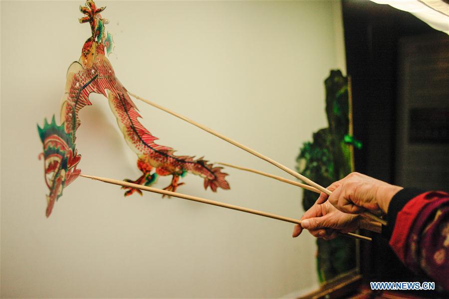 Zhang Kunrong demonstrates in a shadow puppetry show in Haining City, east China\'s Zhejiang Province, Nov. 20, 2018. Zhang Kunrong, 79, a locally born shadow puppetry player, is an inheritor of the Haining shadow puppetry, a form of traditional theatre acted by colorful silhouette figures made from leather or paper, accompanied by music and singing. A typical variety popular in south China, Haining shadow puppetry, a national intangible cultural heritage, has a history of about 900 years dating back to the Southern Song Dynasty (AD 1127-1279). Obsessed with the shadow play since childhood, Zhang Kunrong was recruited to the provincial shadow puppetry troupe in 1958 and soon became a mainstay after two year\'s practice and in the later years staged performances at home and abroad as Haining shadow puppetry grows popular. Nowadays, Zhang works more on script writing, directing and teaching apprentices. Haining shadow puppetry was listed as one of the state-level intangible cultural heritages in 2006 and was included in the UNESCO Intangible Cultural Heritage of Humanity list in 2011. (Xinhua/Zhu Weixi)