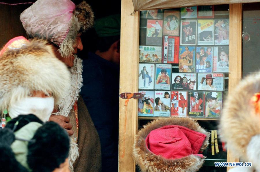 File photo taken in 1987 shows people of Tibetan ethnic group listening to pop music outside a tape store in Xiahe County, northwest China\'s Gansu Province. From 1978 when China started its reform and opening-up policy, a door to the outside world has been opened. Along with the imported commodities, fashion ideas inevitably slipped into China and since then the country, which was somewhat lack of fashion diversity, started its journey to pursue fashions. Over the past four decades, the thirst for beauty has driven Chinese people to pursue every possible fashionable element. The change first came with dress when colorful and diversified clothing prevailed as against the former dominant blue and grey. For a time, men and women raced to hairdressers\' just for trendy hairdos. Eating McDonald\'s or western cuisine even once was regarded as a fashionable thing. However, the most conspicuous change is that Chinese people have become more inclusive and they tend to accept new fashions, styles and concepts. China nowadays is dazzling the world not only on the fashion stage but in many other fields. Changes in fashions, as a profile of society, has well interpreted the benefits to people brought by China\'s reform and opening-up policy. (Xinhua)