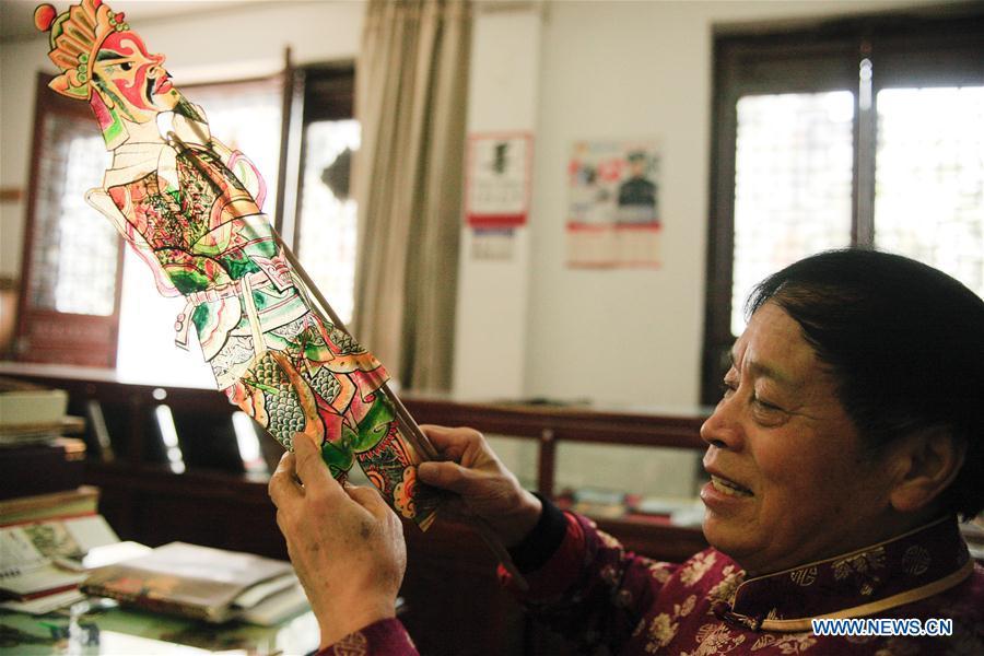 Zhang Kunrong sews parts together to make a shadow puppetry piece in Haining City, east China\'s Zhejiang Province, Nov. 20, 2018. Zhang Kunrong, 79, a locally born shadow puppetry player, is an inheritor of the Haining shadow puppetry, a form of traditional theatre acted by colorful silhouette figures made from leather or paper, accompanied by music and singing. A typical variety popular in south China, Haining shadow puppetry, a national intangible cultural heritage, has a history of about 900 years dating back to the Southern Song Dynasty (AD 1127-1279). Obsessed with the shadow play since childhood, Zhang Kunrong was recruited to the provincial shadow puppetry troupe in 1958 and soon became a mainstay after two year\'s practice and in the later years staged performances at home and abroad as Haining shadow puppetry grows popular. Nowadays, Zhang works more on script writing, directing and teaching apprentices. Haining shadow puppetry was listed as one of the state-level intangible cultural heritages in 2006 and was included in the UNESCO Intangible Cultural Heritage of Humanity list in 2011. (Xinhua/Zhu Weixi)