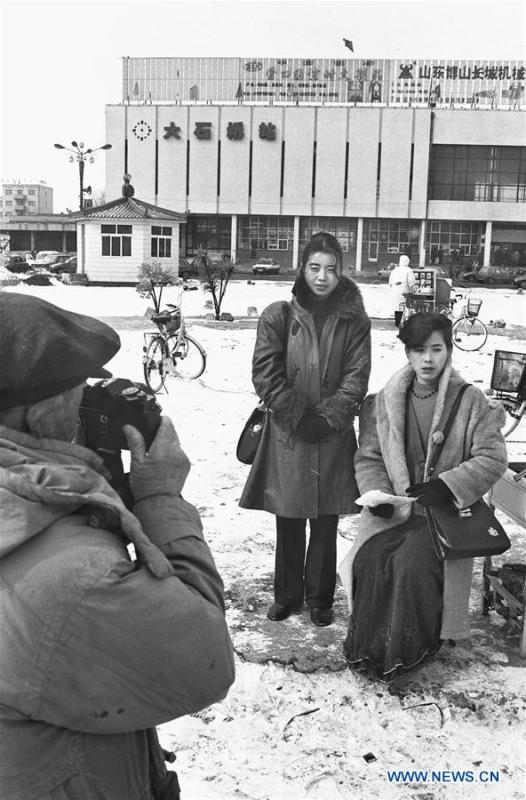 File photo issued on Feb. 24, 1997 shows residents in fashionable costumes posing for photo at a railway station in Dashiqiao, northeast China\'s Liaoning Province. From 1978 when China started its reform and opening-up policy, a door to the outside world has been opened. Along with the imported commodities, fashion ideas inevitably slipped into China and since then the country, which was somewhat lack of fashion diversity, started its journey to pursue fashions. Over the past four decades, the thirst for beauty has driven Chinese people to pursue every possible fashionable element. The change first came with dress when colorful and diversified clothing prevailed as against the former dominant blue and grey. For a time, men and women raced to hairdressers\' just for trendy hairdos. Eating McDonald\'s or western cuisine even once was regarded as a fashionable thing. However, the most conspicuous change is that Chinese people have become more inclusive and they tend to accept new fashions, styles and concepts. China nowadays is dazzling the world not only on the fashion stage but in many other fields. Changes in fashions, as a profile of society, has well interpreted the benefits to people brought by China\'s reform and opening-up policy. (Xinhua/Li Yonghong)