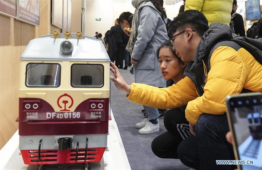 Visitors look at the model of locomotive during a major exhibition to commemorate the 40th anniversary of China\'s reform and opening-up at the National Museum of China in Beijing, capital of China, Nov. 24, 2018. (Xinhua/Yin Gang)
