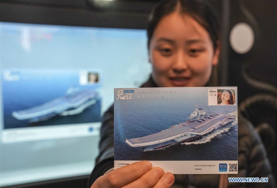 A visitor displays a customized postcard at the exhibition area of Xinhua News Agency during a major exhibition to commemorate the 40th anniversary of China\'s reform and opening-up at the National Museum of China in Beijing, capital of China, Nov. 24, 2018. (Xinhua/Yin Gang)