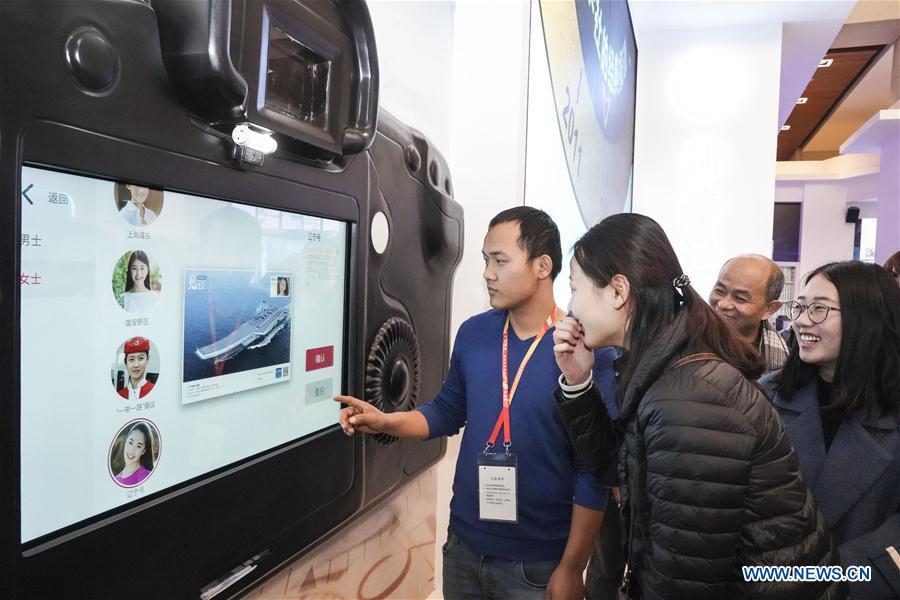 Visitors experience customized postcard making at the exhibition area of Xinhua News Agency during a major exhibition to commemorate the 40th anniversary of China\'s reform and opening-up at the National Museum of China in Beijing, capital of China, Nov. 24, 2018. (Xinhua/Yin Gang)