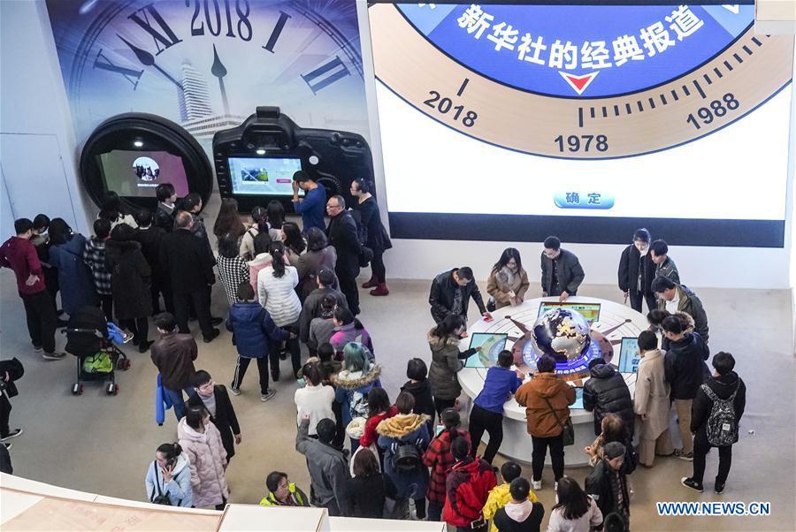 Visitors experience customized postcard making at the exhibition area of Xinhua News Agency during a major exhibition to commemorate the 40th anniversary of China\'s reform and opening-up at the National Museum of China in Beijing, capital of China, Nov. 24, 2018. (Xinhua/Yin Gang)