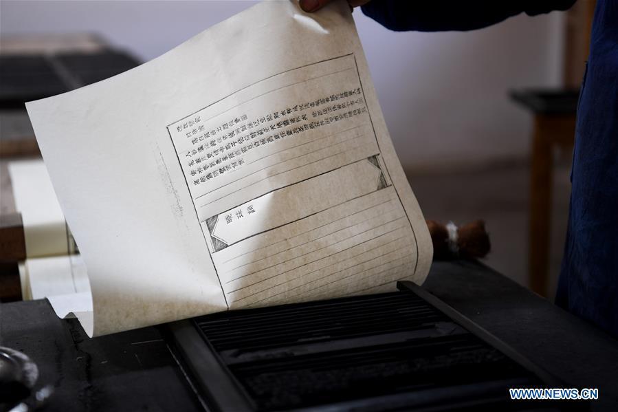 Lei Shitai works on a paper as he prints a book in Chanshan Village of Qinxi Town, Jingxian County, in east China\'s Anhui Province, Nov. 23, 2018. Lei, 52, born in neighboring Jiangxi Province, started his career as a typography printer when he finished his apprenticeship with his uncle who he followed since he was 17. The traditional printing method witnessed an increasingly hard time in the recent years as a livelihood. It was in 2017 when he decided to move to Chanshan at the invitation of Kai Yuanhong, a local cabinet maker, to cooperate in a broader way. Lei is now working with the traditional technique in a larger scale. (Xinhua/Zhang Duan)
