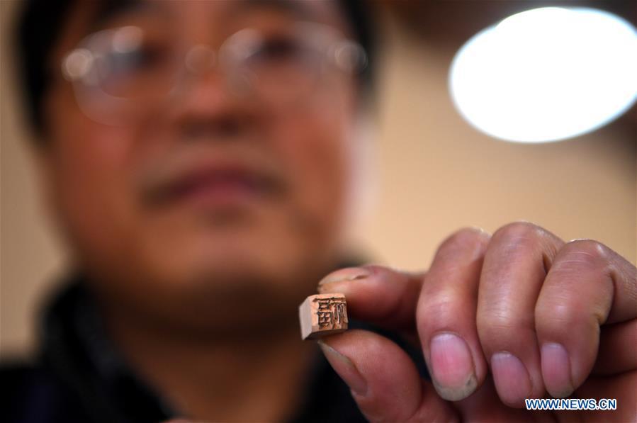 Lei Shitai presents a printing character in Chanshan Village of Qinxi Town, Jingxian County, in east China\'s Anhui Province, Nov. 23, 2018. Lei, 52, born in neighboring Jiangxi Province, started his career as a typography printer when he finished his apprenticeship with his uncle who he followed since he was 17. The traditional printing method witnessed an increasingly hard time in the recent years as a livelihood. It was in 2017 when he decided to move to Chanshan at the invitation of Kai Yuanhong, a local cabinet maker, to cooperate in a broader way. Lei is now working with the traditional technique in a larger scale. (Xinhua/Liu Junxi)