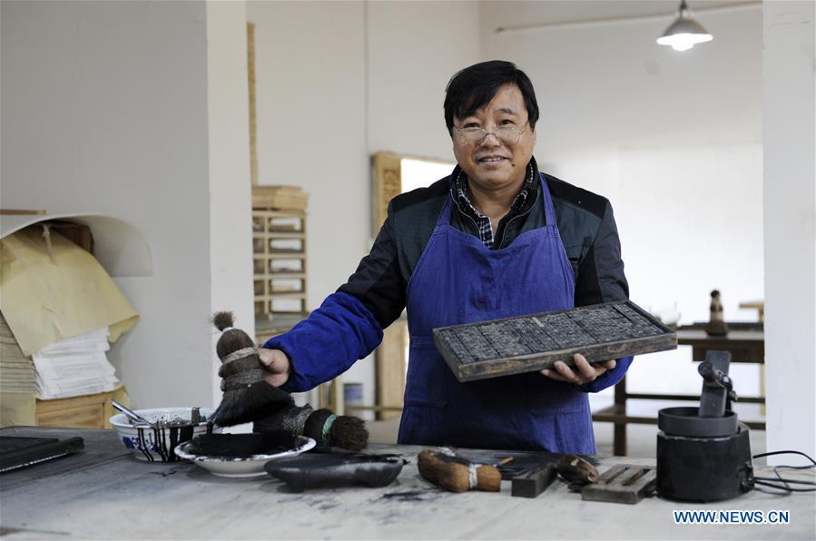 Lei Shitai presents his printing tools in Chanshan Village of Qinxi Town, Jingxian County, in east China\'s Anhui Province, Nov. 23, 2018. Lei, 52, born in neighboring Jiangxi Province, started his career as a typography printer when he finished his apprenticeship with his uncle who he followed since he was 17. The traditional printing method witnessed an increasingly hard time in the recent years as a livelihood. It was in 2017 when he decided to move to Chanshan at the invitation of Kai Yuanhong, a local cabinet maker, to cooperate in a broader way. Lei is now working with the traditional technique in a larger scale. (Xinhua/Xu Liang)