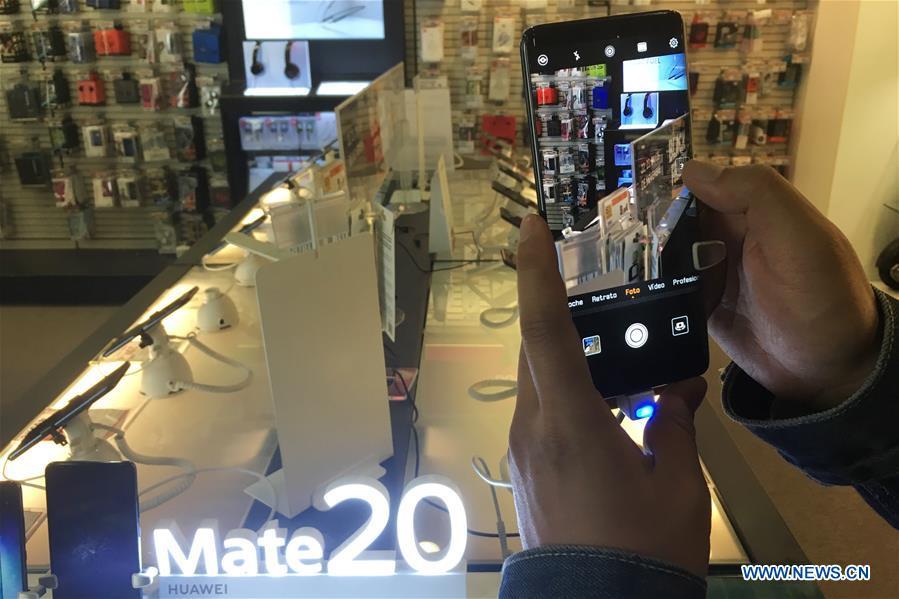 People tries a Huawei smart phone in a shopping mall in Barcelona, Spain, on Nov. 25, 2018. More and more Spanish consumers accept Chinese high-tech brands, which now can be seen in daily life across Spain. (Xinhua/Zheng Huansong)