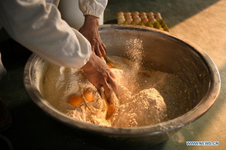 A worker makes noodles in a factory in Gengjiazhuang Village of Gaocheng District in Shijiazhuang, capital of north China\'s Hebei Province, Nov. 23, 2018. The fine dried noodle produced in Gongcheng, formerly article of tribute to the imperial family, is famous for its thin but hollow strings that is a result of more than ten working procedures. (Xinhua/Zheng Yaning)