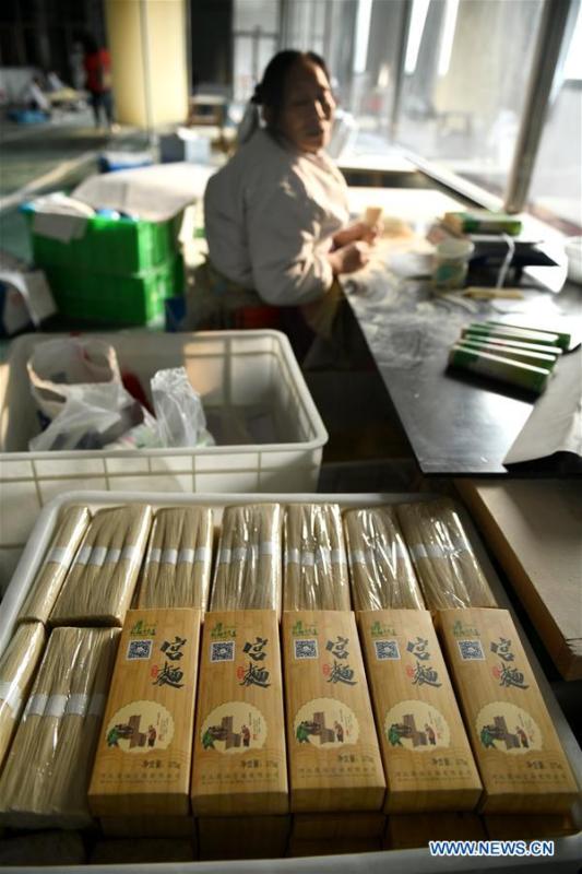 A worker packs the dried noodles in a factory in Gengjiazhuang Village of Gaocheng District in Shijiazhuang, capital of north China\'s Hebei Province, Nov. 23, 2018. The fine dried noodle produced in Gongcheng, formerly article of tribute to the imperial family, is famous for its thin but hollow strings that is a result of more than ten working procedures. (Xinhua/Chen Qibao)