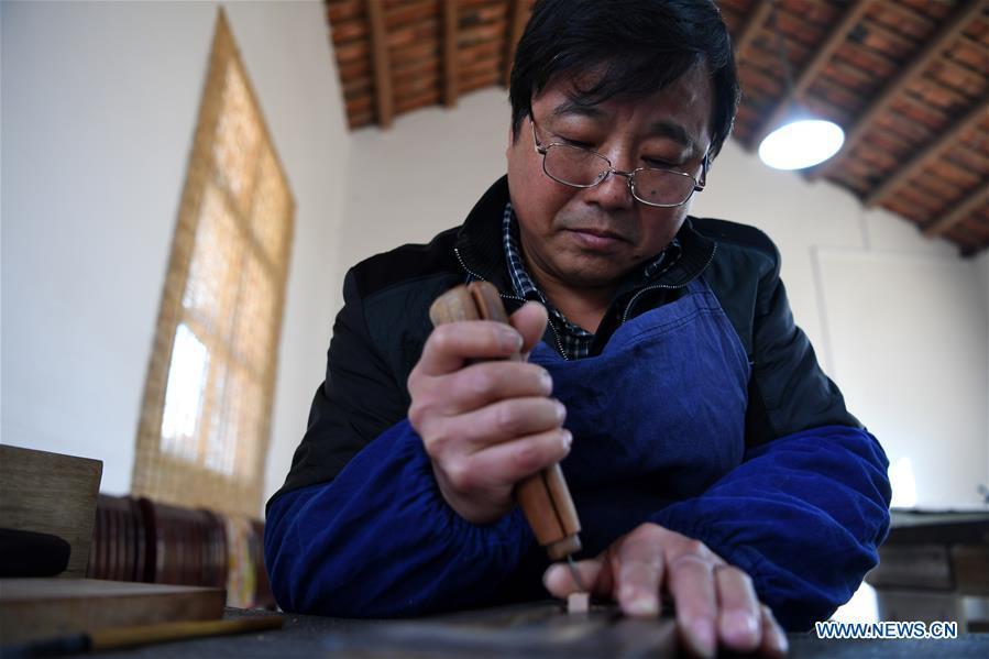 Lei Shitai works in Chanshan Village of Qinxi Town, Jingxian County, in east China\'s Anhui Province, Nov. 23, 2018. Lei, 52, born in neighboring Jiangxi Province, started his career as a typography printer when he finished his apprenticeship with his uncle who he followed since he was 17. The traditional printing method witnessed an increasingly hard time in the recent years as a livelihood. It was in 2017 when he decided to move to Chanshan at the invitation of Kai Yuanhong, a local cabinet maker, to cooperate in a broader way. Lei is now working with the traditional technique in a larger scale. (Xinhua/Liu Junxi)