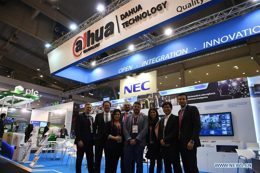 Staff members of Zhejiang Dahua Technology Co. Ltd. pose for a group photo during the Smart City Expo World Congress in Barcelona, Spain, on Nov. 15, 2017. More and more Spanish consumers accept Chinese high-tech brands, which now can be seen in daily life across Spain.(Xinhua/Guo Qiuda)