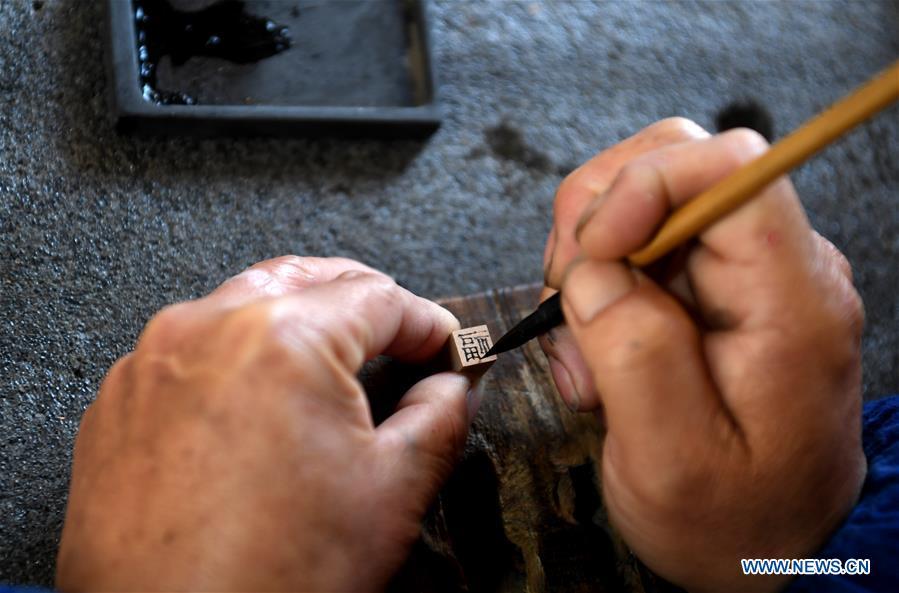 Lei Shitai works in Chanshan Village of Qinxi Town, Jingxian County, in east China\'s Anhui Province, Nov. 23, 2018. Lei, 52, born in neighboring Jiangxi Province, started his career as a typography printer when he finished his apprenticeship with his uncle who he followed since he was 17. The traditional printing method witnessed an increasingly hard time in the recent years as a livelihood. It was in 2017 when he decided to move to Chanshan at the invitation of Kai Yuanhong, a local cabinet maker, to cooperate in a broader way. Lei is now working with the traditional technique in a larger scale. (Xinhua/Liu Junxi)