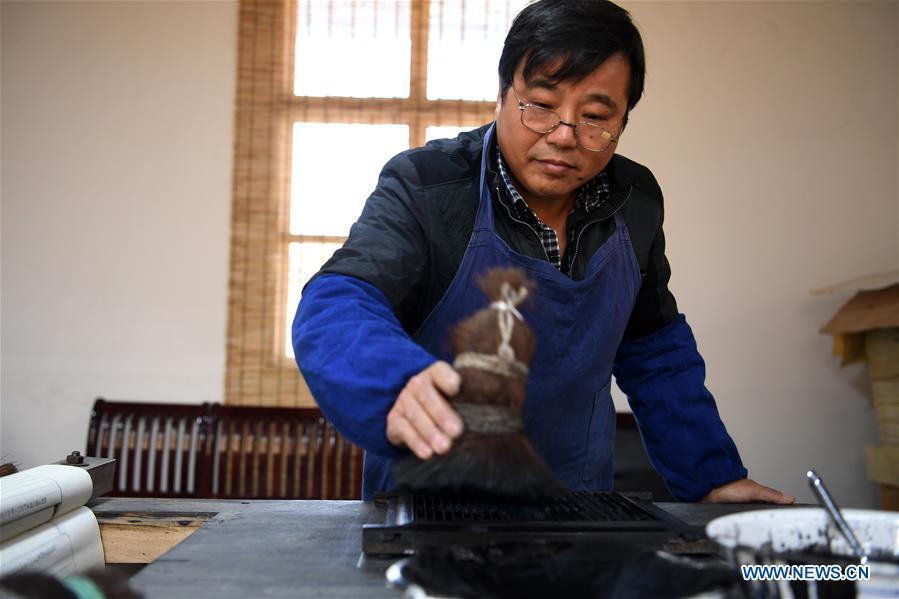Lei Shitai works in Chanshan Village of Qinxi Town, Jingxian County, in east China\'s Anhui Province, Nov. 23, 2018. Lei, 52, born in neighboring Jiangxi Province, started his career as a typography printer when he finished his apprenticeship with his uncle who he followed since he was 17. The traditional printing method witnessed an increasingly hard time in the recent years as a livelihood. It was in 2017 when he decided to move to Chanshan at the invitation of Kai Yuanhong, a local cabinet maker, to cooperate in a broader way. Lei is now working with the traditional technique in a larger scale. (Xinhua/Zhang Duan)
