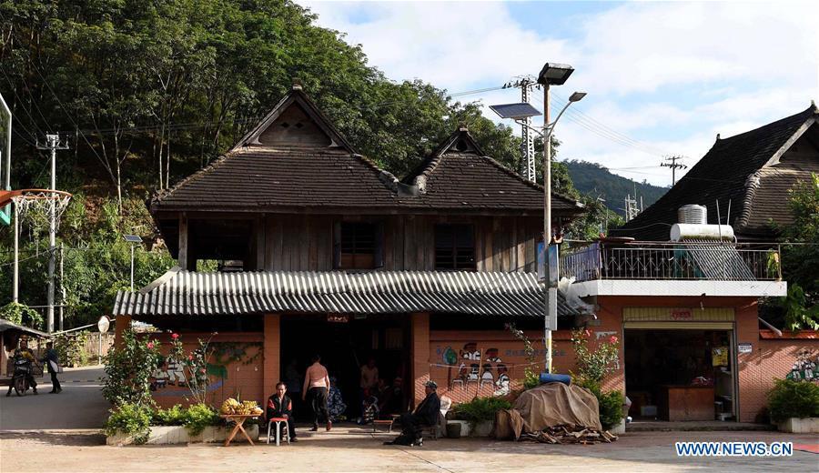 Photo taken on Nov. 5, 2015 shows a residence in Bapiao Village of Jino Ethnic Township on Jino Mountain in Jinghong of Xishuangbanna Dai Autonomous Prefecture, southwest China\'s Yunnan Province. Solar-power street lights are already in use in the village. With a population of slightly over 20,000, the Jino people had only been officially acknowledged in 1979 as an independent ethnic group of China. Until 1949, most of them had lived for generations in primitive mountain tribes in southwest China\'s Yunnan Province. Over the four decades since it embraced the reform and opening-up policy, China has spared no effort to support ethnic groups with smaller populations. Life on Jino Mountain, where most Jino communities are located, saw positive changes in parallel with improvements in local politics, economy, technology, education, culture, health care, ecology, ethnic development and other social undertakings. Just like its 55 ethnic brethren, the Jino people also benefit from China\'s reform and opening-up in seeking a prosperous life. In Jino Ethnic Township on the Jino Mountain, residents now have direct access to road, water, electricity, TV and radio, as well as the mobile network. Ninety percent of the residents have moved into new houses. Most residents own motorcycles and tractors, and some of them have purchased cars. More people have increased their income by selling local specialty products via the internet, whereas in the past, doing business was perceived as a shame. Currently, the primary education in Jino Ethnic Township achieved 100 percent coverage for all school-age children. More than 99 percent of residents have joined the rural cooperative medical insurance programme. The Jino ethnic culture undergoes protection and inheritance: the great drum dance of the Jino people has been listed as one of China\'s national intangible cultural heritages. (Xinhua/Lin Yiguang)