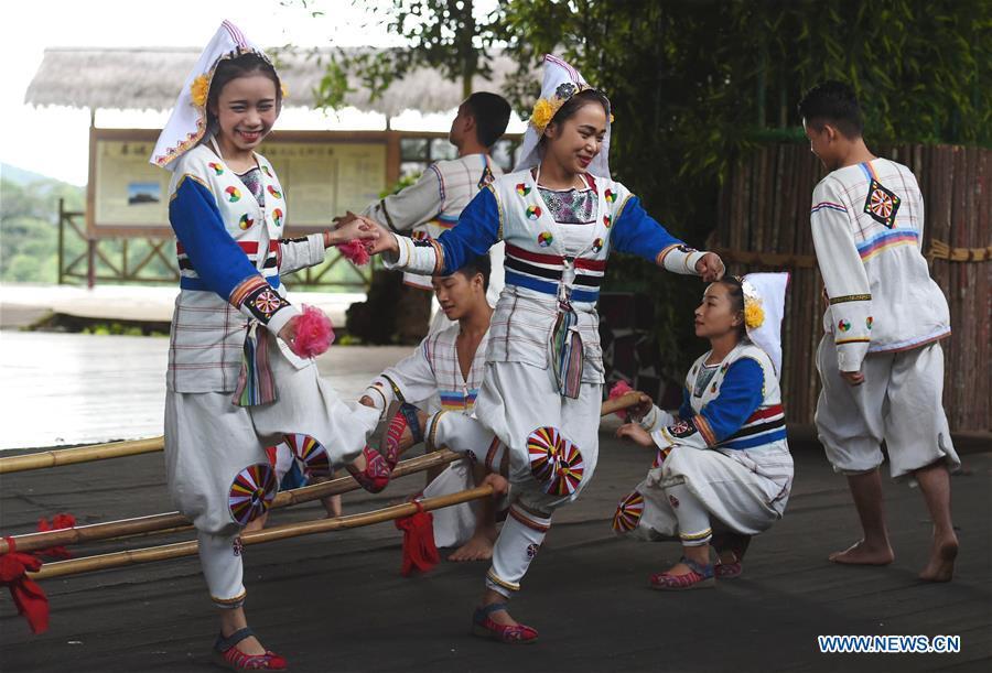 Jino youths perform a folk dance for tourists in Bapo Village of Jino Ethnic Township on Jino Mountain, Jinghong, in Xishuangbanna Dai Autonomous Prefecture, southwest China\'s Yunnan Province, Nov. 5, 2015. With a population of slightly over 20,000, the Jino people had only been officially acknowledged in 1979 as an independent ethnic group of China. Until 1949, most of them had lived for generations in primitive mountain tribes in southwest China\'s Yunnan Province. Over the four decades since it embraced the reform and opening-up policy, China has spared no effort to support ethnic groups with smaller populations. Life on Jino Mountain, where most Jino communities are located, saw positive changes in parallel with improvements in local politics, economy, technology, education, culture, health care, ecology, ethnic development and other social undertakings. Just like its 55 ethnic brethren, the Jino people also benefit from China\'s reform and opening-up in seeking a prosperous life. In Jino Ethnic Township on the Jino Mountain, residents now have direct access to road, water, electricity, TV and radio, as well as the mobile network. Ninety percent of the residents have moved into new houses. Most residents own motorcycles and tractors, and some of them have purchased cars. More people have increased their income by selling local specialty products via the internet, whereas in the past, doing business was perceived as a shame. Currently, the primary education in Jino Ethnic Township achieved 100 percent coverage for all school-age children. More than 99 percent of residents have joined the rural cooperative medical insurance programme. The Jino ethnic culture undergoes protection and inheritance: the great drum dance of the Jino people has been listed as one of China\'s national intangible cultural heritages. (Xinhua/Lin Yiguang)