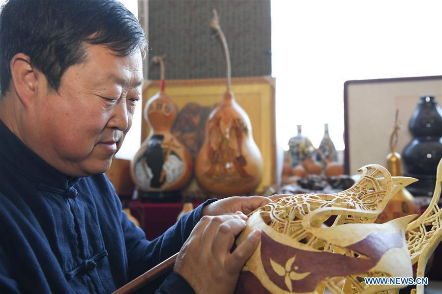 Wang Guowei carves gourd handicraft at his studio in Tieling, northeast China\'s Liaoning Province, Nov. 26, 2018. Wang Guowei who is adept in painting was awarded provincial-level handicraft master title for producing exquisite gourd handicrafts with vivid images. (Xinhua/Long Lei)