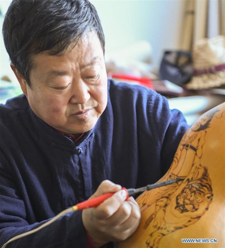 Wang Guowei makes gourd handicraft at his studio in Tieling, northeast China\'s Liaoning Province, Nov. 26, 2018. Wang Guowei who is adept in painting was awarded provincial-level handicraft master title for producing exquisite gourd handicrafts with vivid images. (Xinhua/Long Lei)