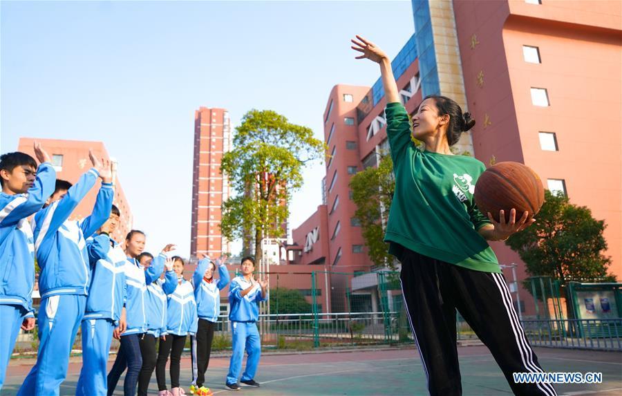 Teacher Zeng Wenping (R) plays basketball with students at Qiyin school in Nanchang, capital of east China\'s Jiangxi Province, Nov. 26, 2018. Zeng, 43, has been engaged in special education for 21 years ever since she graduated from university. Hearing impaired students enjoy the all-encompassing heartfelt and intensive care by Zeng and consider her as more than a teacher but a sister. (Xinhua/Hu Chenhuan)