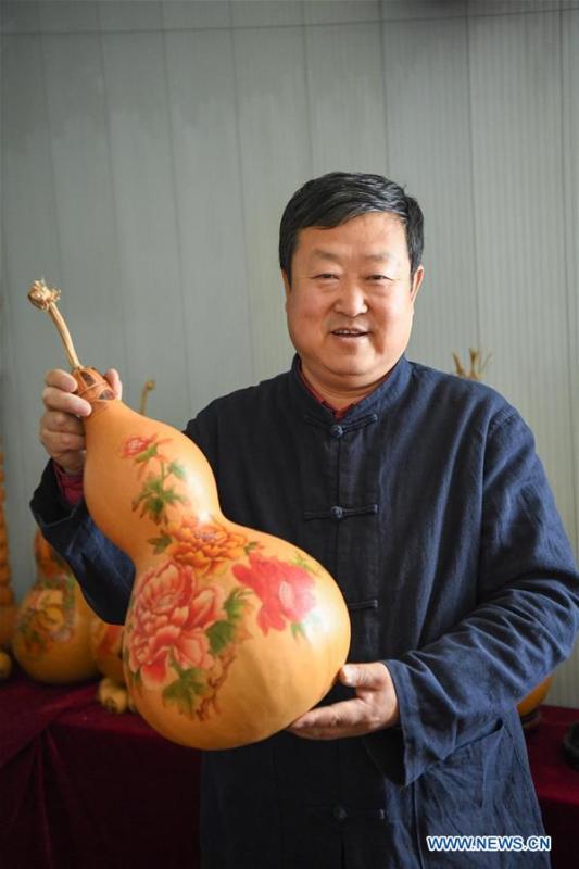 Wang Guowei displays gourd handicraft at his studio in Tieling, northeast China\'s Liaoning Province, Nov. 26, 2018. Wang Guowei who is adept in painting was awarded provincial-level handicraft master title for producing exquisite gourd handicrafts with vivid images. (Xinhua/Long Lei)