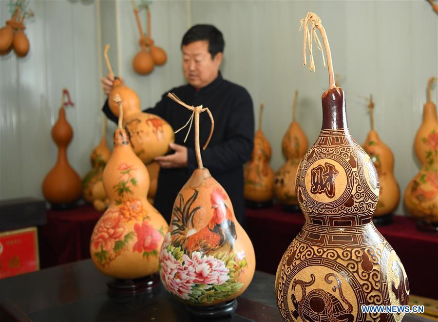 Wang Guowei arranges gourd handicrafts at his studio in Tieling, northeast China\'s Liaoning Province, Nov. 26, 2018. Wang Guowei who is adept in painting was awarded provincial-level handicraft master title for producing exquisite gourd handicrafts with vivid images. (Xinhua/Long Lei)