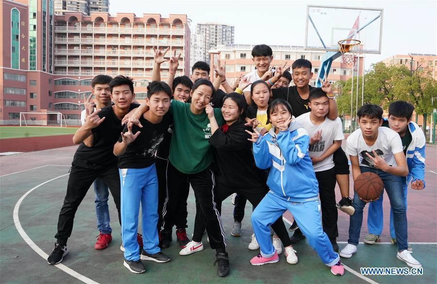 Teacher Zeng Wenping (in green shirt) poses for a photo with her students at Qiyin school in Nanchang, capital of east China\'s Jiangxi Province, Nov. 26, 2018. Zeng, 43, has been engaged in special education for 21 years ever since she graduated from university. Hearing impaired students enjoy the all-encompassing heartfelt and intensive care by Zeng and consider her as more than a teacher but a sister. (Xinhua/Hu Chenhuan)