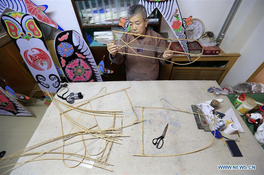 Fu Xianming makes framework of kite in Shijiazhuang, capital of north China\'s Hebei Province, Nov. 21, 2018. Fu Xianming, a 66-year-old craftsman, has devoted himself in kites making for 20 years. Fu and his wife have made more than 1,500 kites of various shapes since 1998. (Xinhua/Zhang Haiqiang)