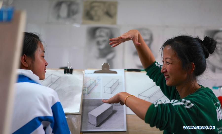 Teacher Zeng Wenping (R) instructs a student in painting at Qiyin school in Nanchang, capital of east China\'s Jiangxi Province, Nov. 26, 2018. Zeng, 43, has been engaged in special education for 21 years ever since she graduated from university. Hearing impaired students enjoy the all-encompassing heartfelt and intensive care by Zeng and consider her as more than a teacher but a sister. (Xinhua/Hu Chenhuan)