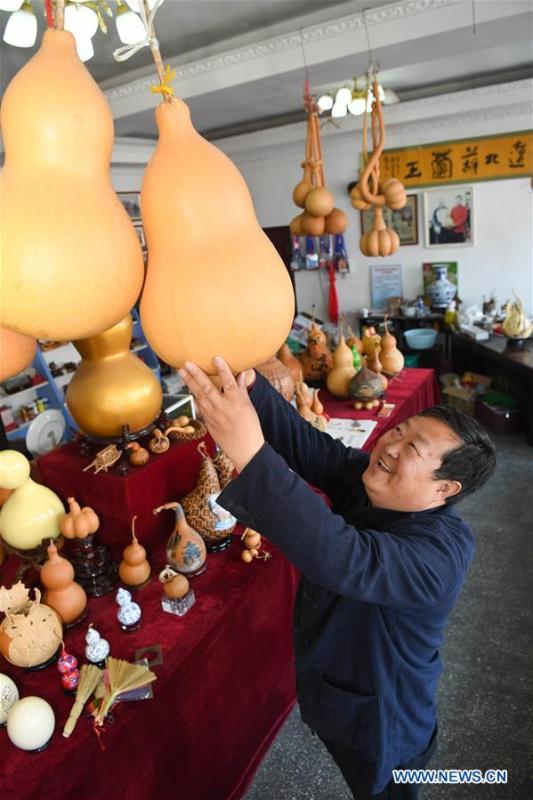 Wang Guowei selects gourd for making gourd handicrafts at his studio in Tieling, northeast China\'s Liaoning Province, Nov. 26, 2018. Wang Guowei who is adept in painting was awarded provincial-level handicraft master title for producing exquisite gourd handicrafts with vivid images. (Xinhua/Long Lei)
