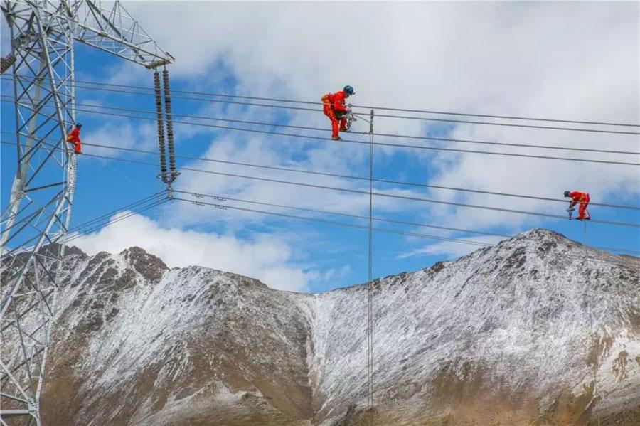 Technicians install spacers on the world\'s highest ultra-high voltage transmission project in southwest China\'s Tibet autonomous region, September, 2018. Workers involved in the project have had to overcome various challenges, including the lack of oxygen at altitudes as high as 5,300 meters above sea-level. (Photo provided by State Grid Qinghai Electric Power Company)