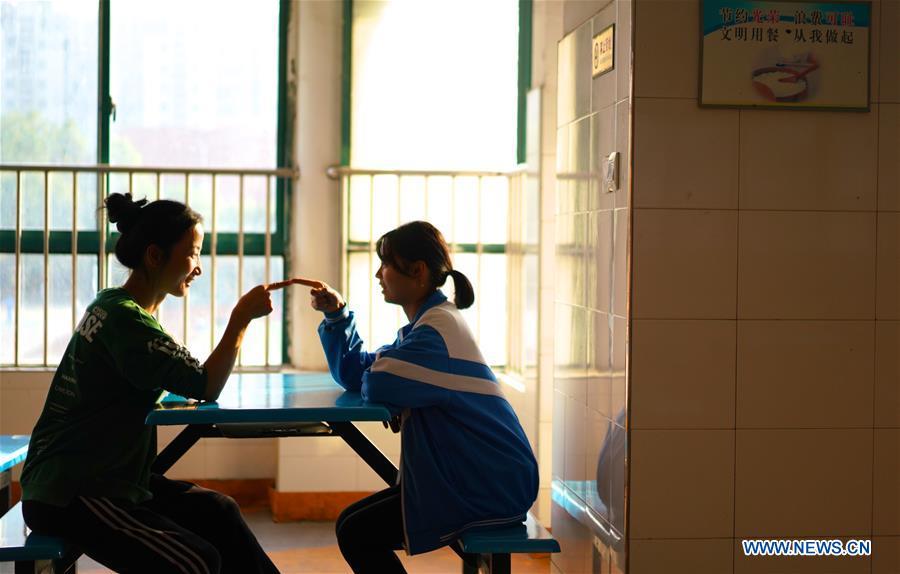 Teacher Zeng Wenping (L) comforts a student at Qiyin school in Nanchang, capital of east China\'s Jiangxi Province, Nov. 26, 2018. Zeng, 43, has been engaged in special education for 21 years ever since she graduated from university. Hearing impaired students enjoy the all-encompassing heartfelt and intensive care by Zeng and consider her as more than a teacher but a sister. (Xinhua/Hu Chenhuan)