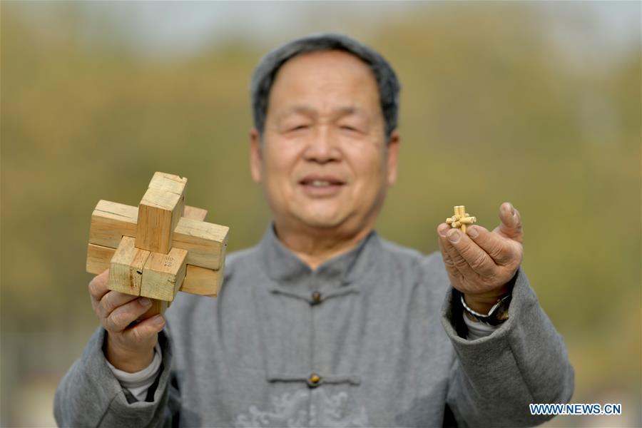 Hou Quanchen shows his self-made Kong Ming Locks in Shahe City, north China\'s Hebei Province on Nov. 28, 2018. Hou Quanchen, who is in his seventies, has devoted himself in the studying and making of Kong Ming Locks and has tried to promote this art among local residents ever since his retirement. (Xinhua/Tian Xiaoli)