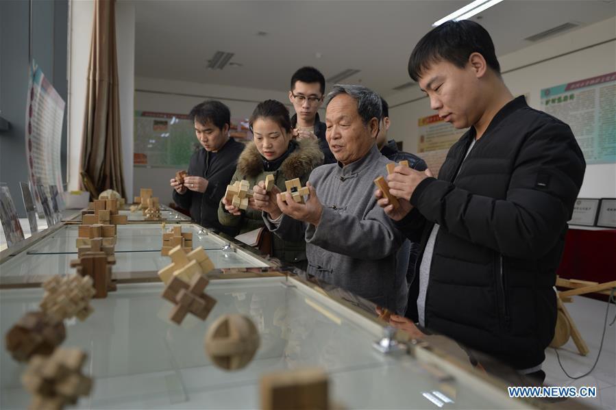 Hou Quanchen introduces Kong Ming Locks to the visitors in Shahe City, north China\'s Hebei Province on Nov. 28, 2018. Hou Quanchen, who is in his seventies, has devoted himself in the studying and making of Kong Ming Locks and has tried to promote this art among local residents ever since his retirement. (Xinhua/Tian Xiaoli)