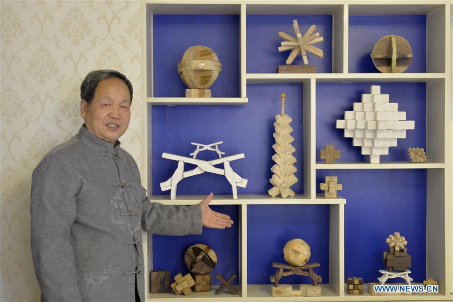 Hou Quanchen introduces Kong Ming Locks to the visitors in Shahe City, north China\'s Hebei Province on Nov. 28, 2018. Hou Quanchen, who is in his seventies, has devoted himself in the studying and making of Kong Ming Locks and has tried to promote this art among local residents ever since his retirement. (Xinhua/Tian Xiaoli)