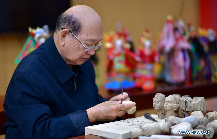 Xu Zhuchu, a national-level intangible cultural heritage inheritor of Zhangzhou wood puppet head carving, carves on a piece of wood to make puppet head at a studio in Zhangzhou City, southeast China\'s Fujian Province, Nov. 28, 2018. Listed as one of the national intangible cultural heritages in 2006, Zhangzhou wood puppet carving features exquisite craftsmanship. Xu\'s works of puppet head carving are known for rich and delicate facial expressions. Nowadays, Xu and his son, Xu Qiang, set up a studio of wood puppet to popularize local puppet culture. (Xinhua/Wei Peiquan)