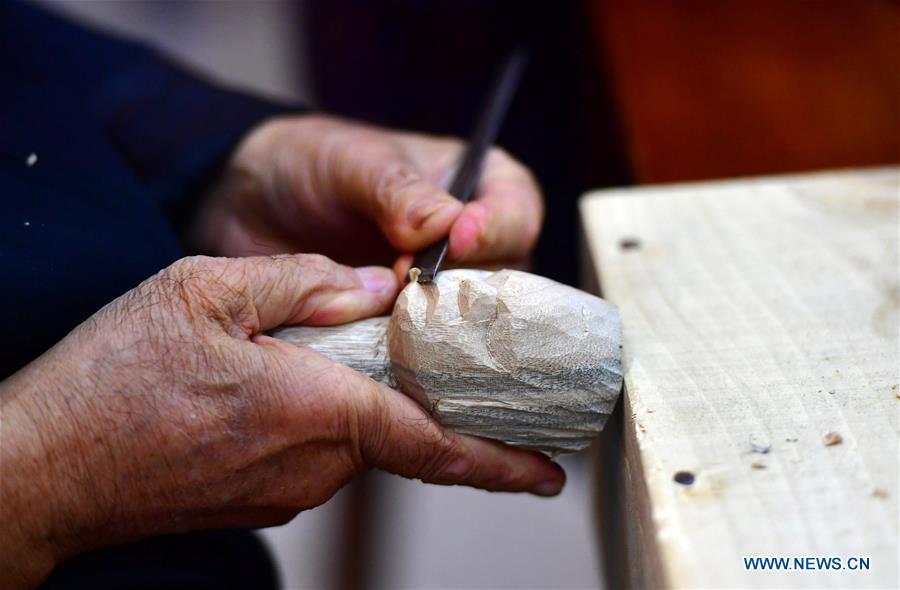Xu Zhuchu, a national-level intangible cultural heritage inheritor of Zhangzhou wood puppet head carving, carves a puppet head at a studio in Zhangzhou City, southeast China\'s Fujian Province, Nov. 28, 2018. Listed as one of the national intangible cultural heritages in 2006, Zhangzhou wood puppet carving features exquisite craftsmanship. Xu\'s works of puppet head carving are known for rich and delicate facial expressions. Nowadays, Xu and his son, Xu Qiang, set up a studio of wood puppet to popularize local puppet culture. (Xinhua/Wei Peiquan)