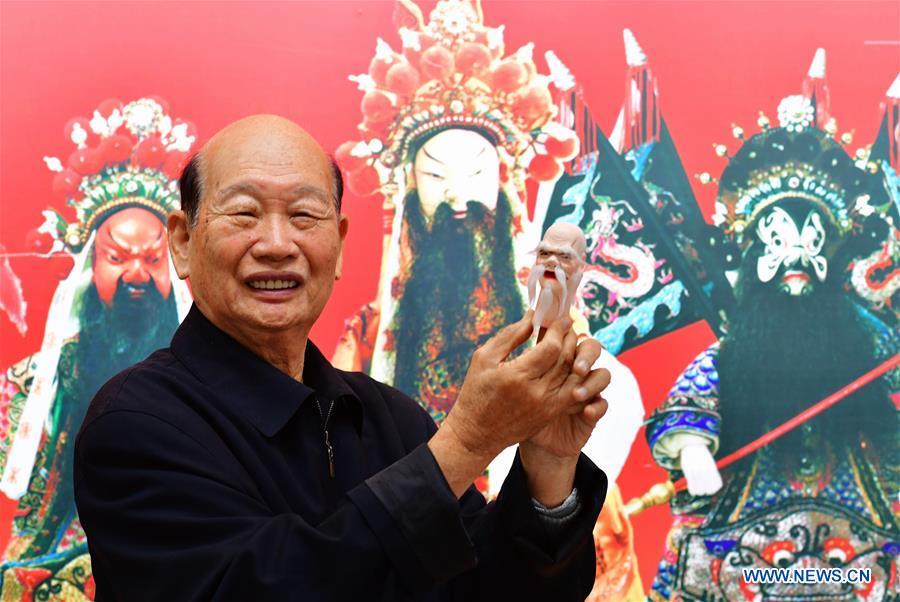 Xu Zhuchu, a national-level intangible cultural heritage inheritor of Zhangzhou wood puppet head carving, displays a wood puppet head at a studio in Zhangzhou City, southeast China\'s Fujian Province, Nov. 28, 2018. Listed as one of the national intangible cultural heritages in 2006, Zhangzhou wood puppet carving features exquisite craftsmanship. Xu\'s works of puppet head carving are known for rich and delicate facial expressions. Nowadays, Xu and his son, Xu Qiang, set up a studio of wood puppet to popularize local puppet culture. (Xinhua/Wei Peiquan)