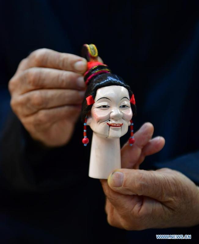 Xu Zhuchu, a national-level intangible cultural heritage inheritor of Zhangzhou wood puppet head carving, displays a wood puppet head at a studio in Zhangzhou City, southeast China\'s Fujian Province, Nov. 28, 2018. Listed as one of the national intangible cultural heritages in 2006, Zhangzhou wood puppet carving features exquisite craftsmanship. Xu\'s works of puppet head carving are known for rich and delicate facial expressions. Nowadays, Xu and his son, Xu Qiang, set up a studio of wood puppet to popularize local puppet culture. (Xinhua/Wei Peiquan)
